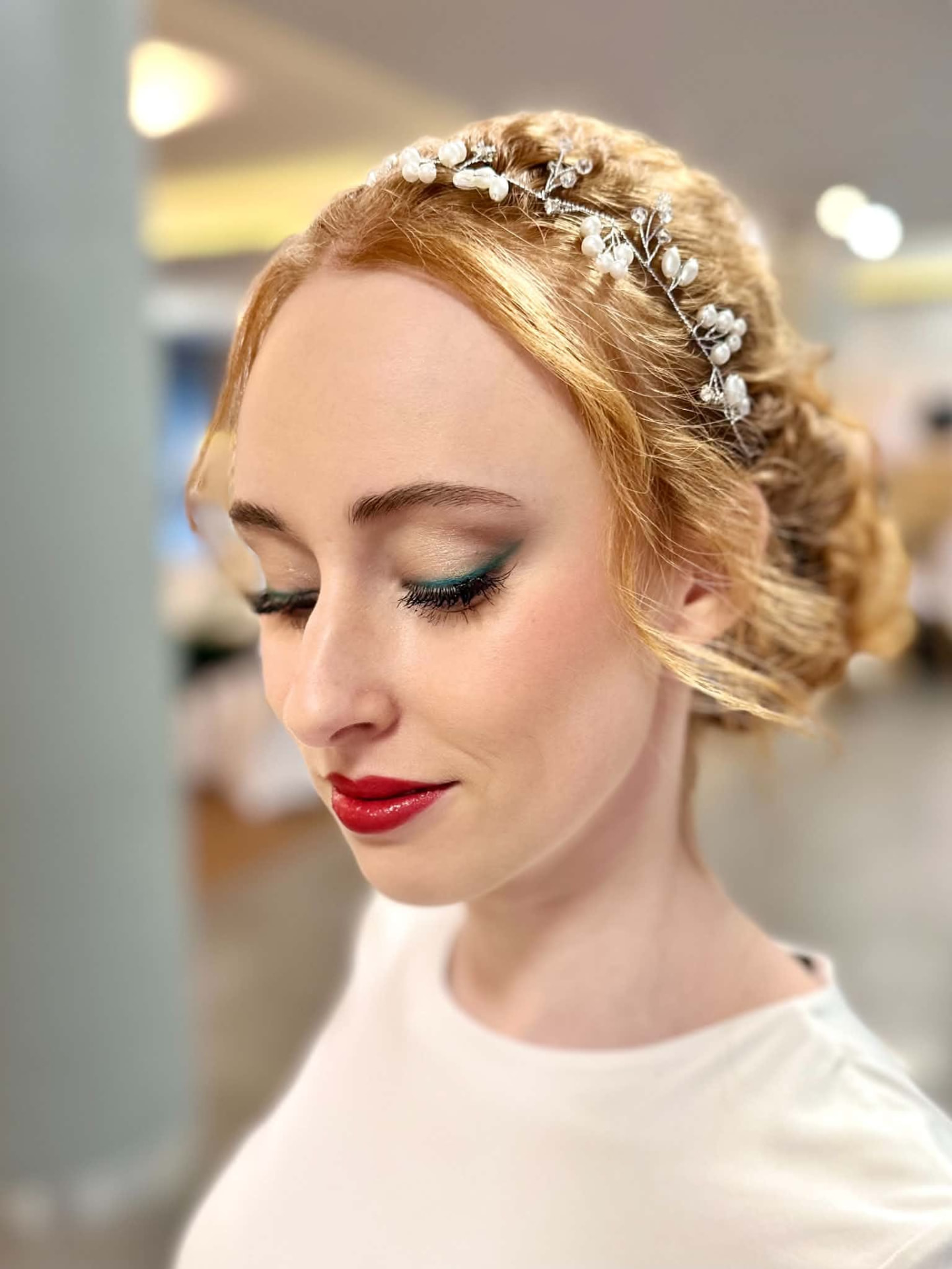 Makijaż z zieloną kreską i czerwonymi ustami przy upiętych włosach z ozdobą — praca Agnieszki w Perfect Beauty